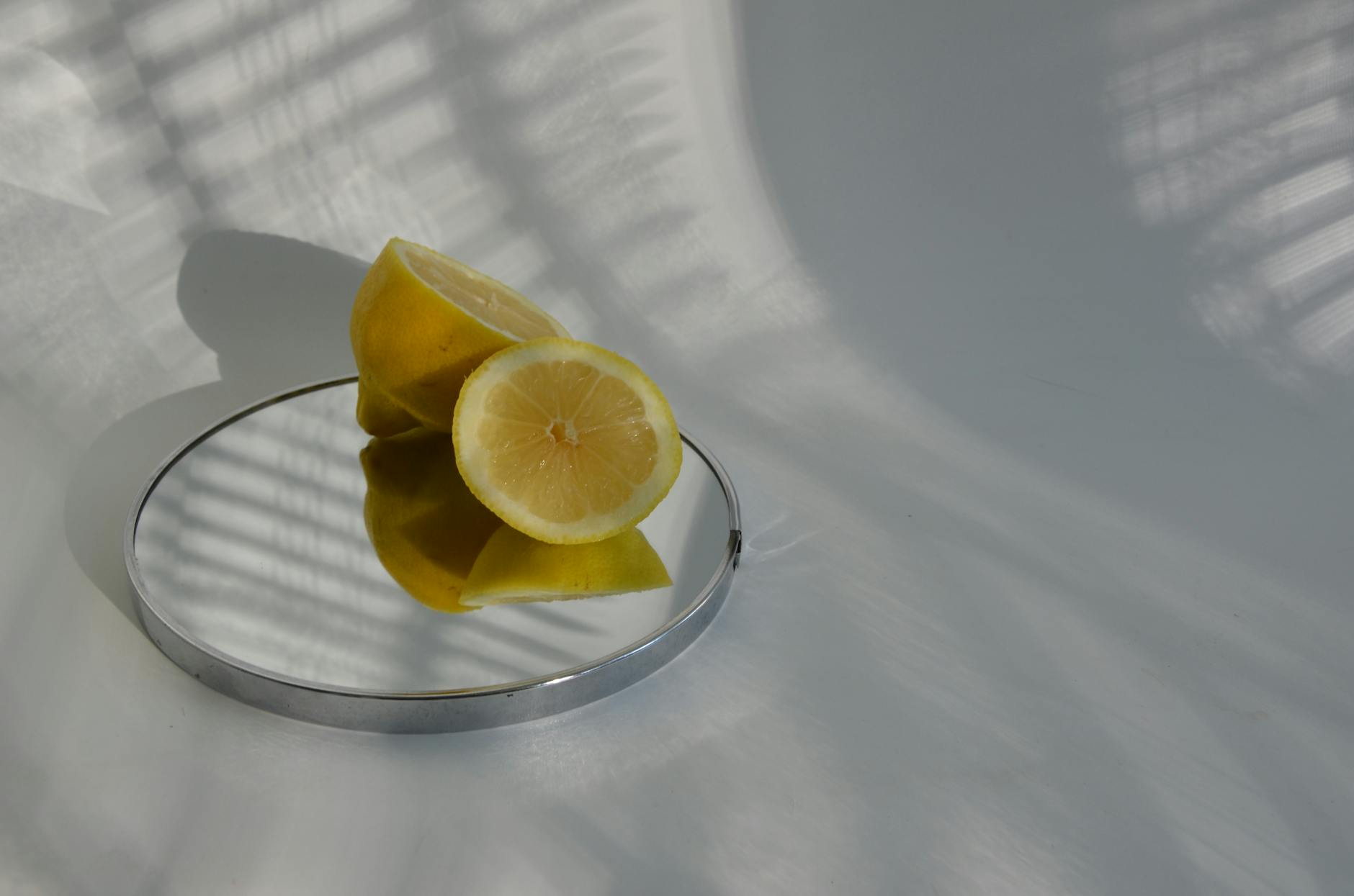 Sliced lemons on a mirror surface, casting shadows