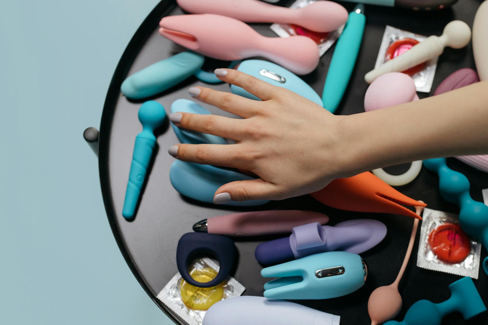 A hand reaching toward vibrators arranged on a surface, representing the journey back to pleasure.