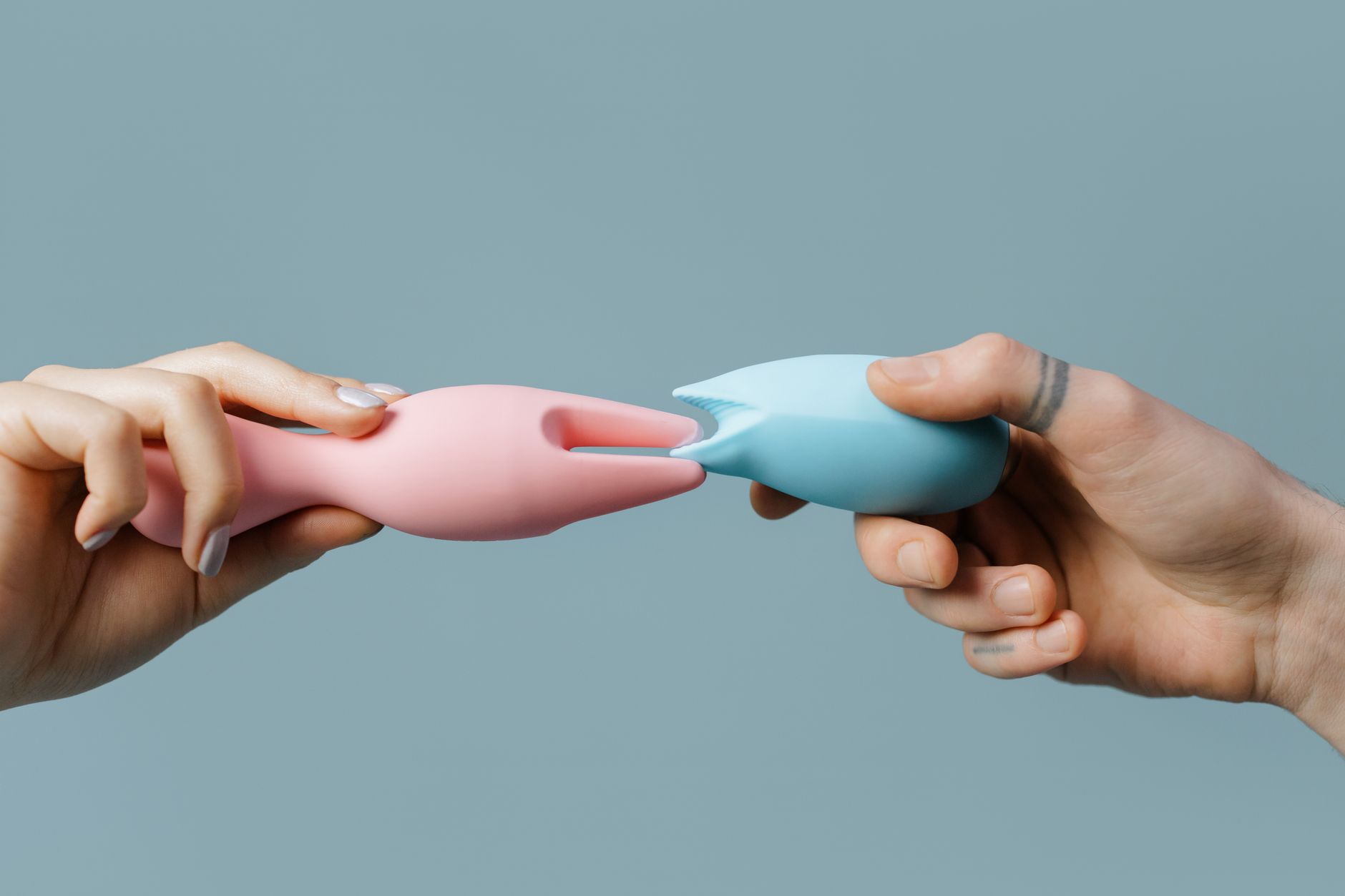 Woman holding blue and pink silicone vibrators, representing accessible pleasure tools for those taking antidepressants