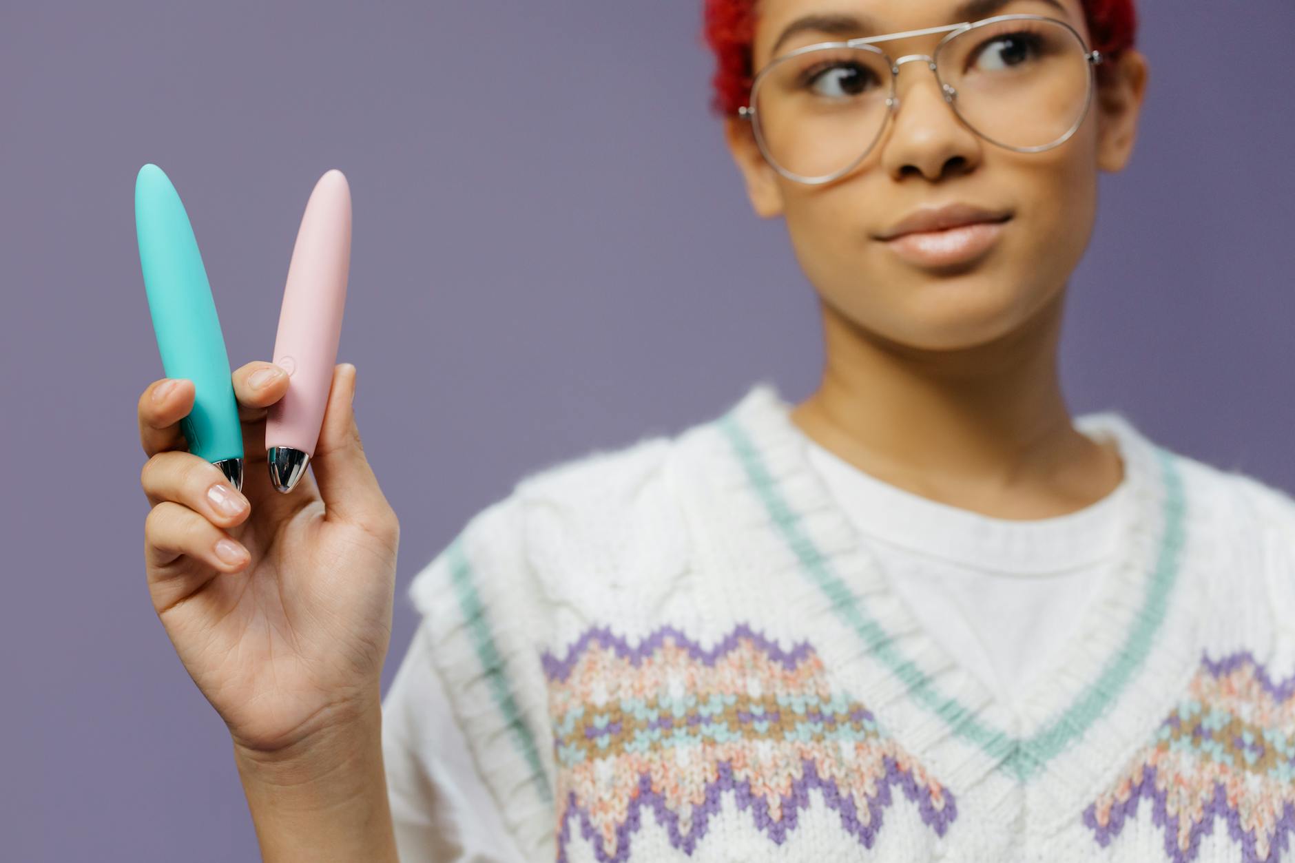 A person holding colorful vibrators, representing options for sensation play with medication